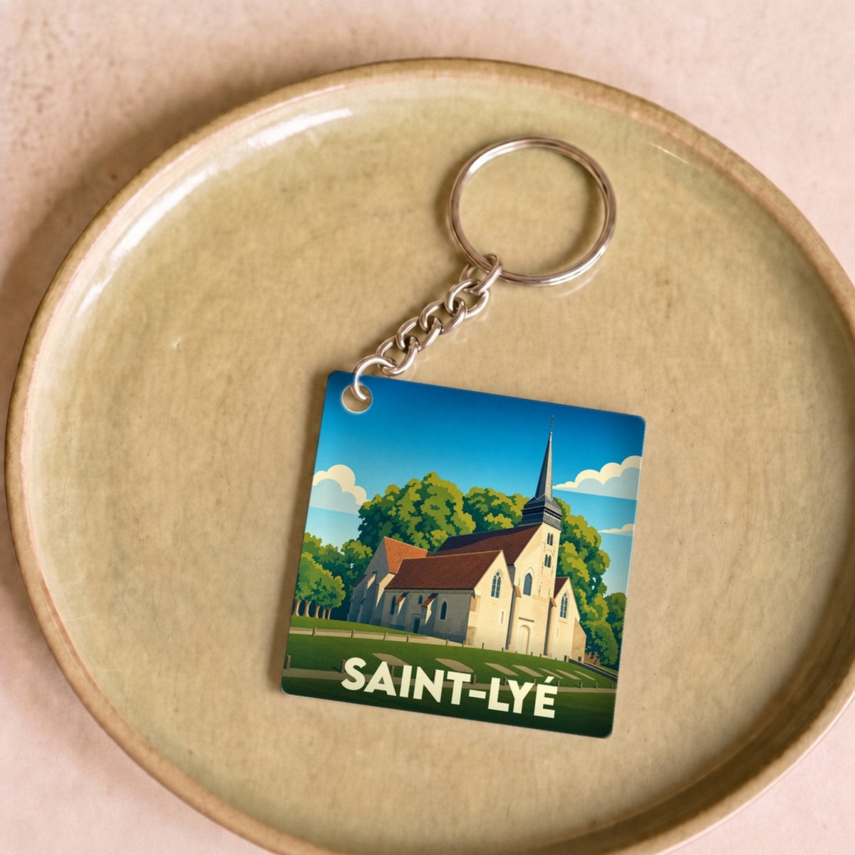 Porte-clés souvenir de la ville de Saint-Lyé avec une illustration stylisée de son église.