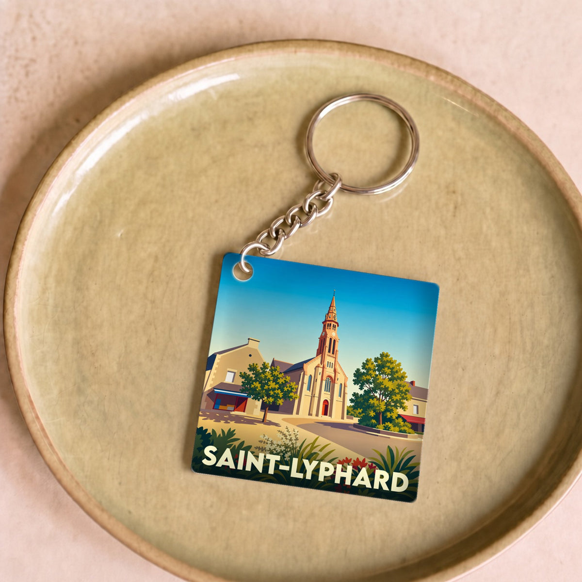 Porte-clés souvenir de la ville de Saint-Lyphard avec une illustration stylisée de son église.