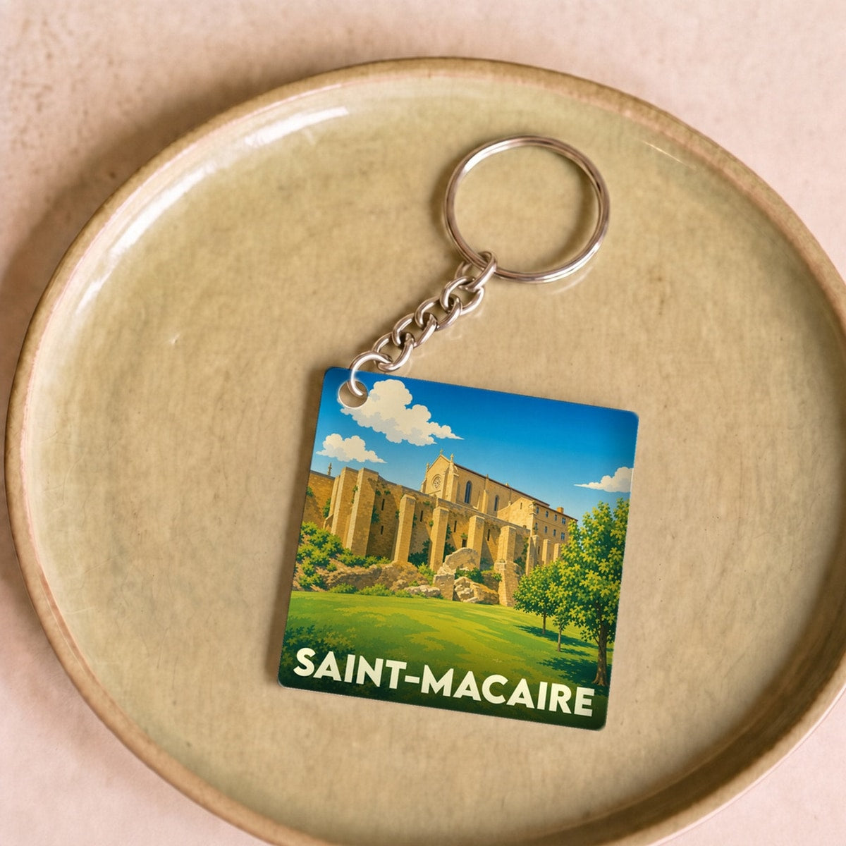 Porte-clés souvenir de la ville de Saint-Macaire avec une illustration stylisée.