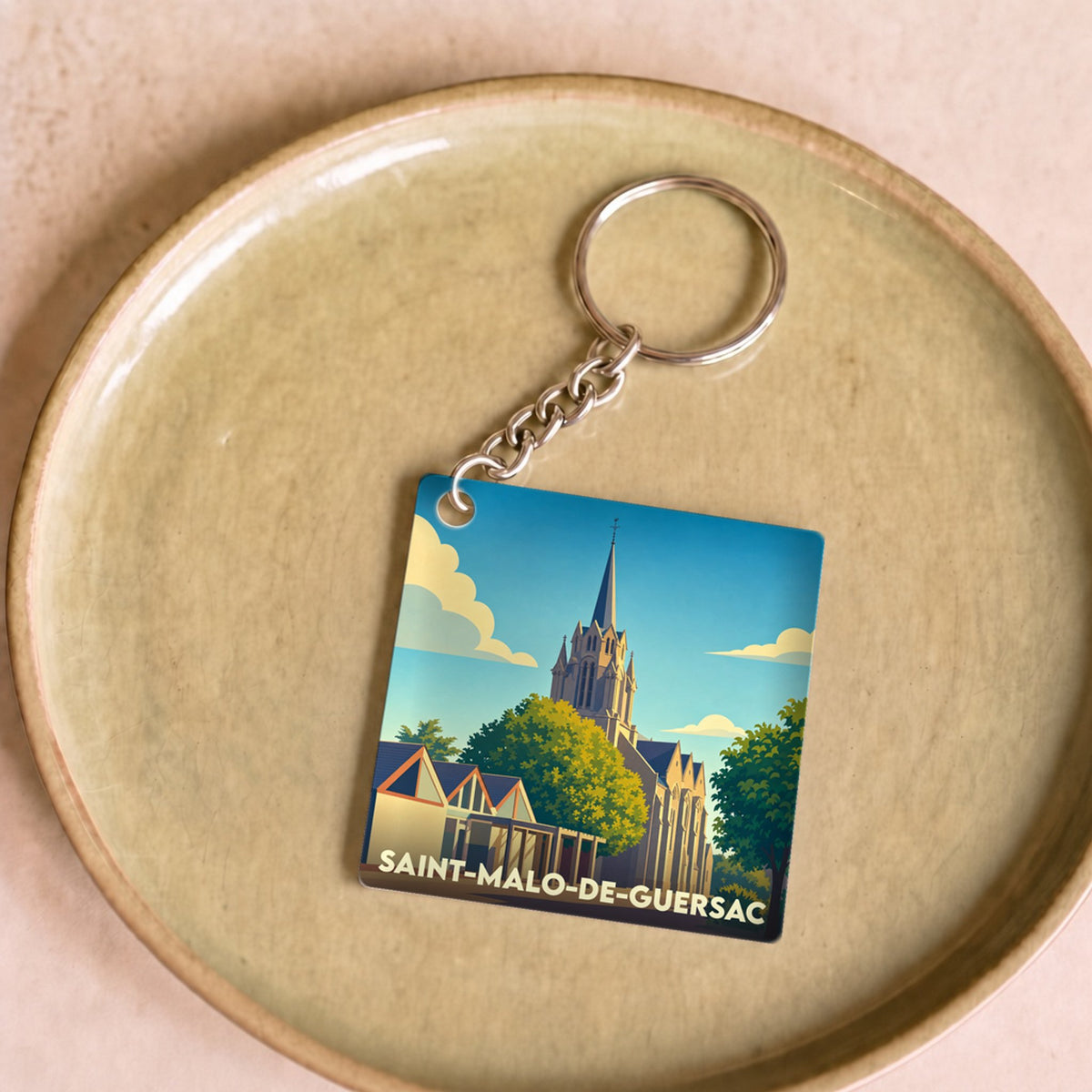 Porte-clés souvenir de Saint-Malo-de-Guersac avec une illustration stylisée de son église.