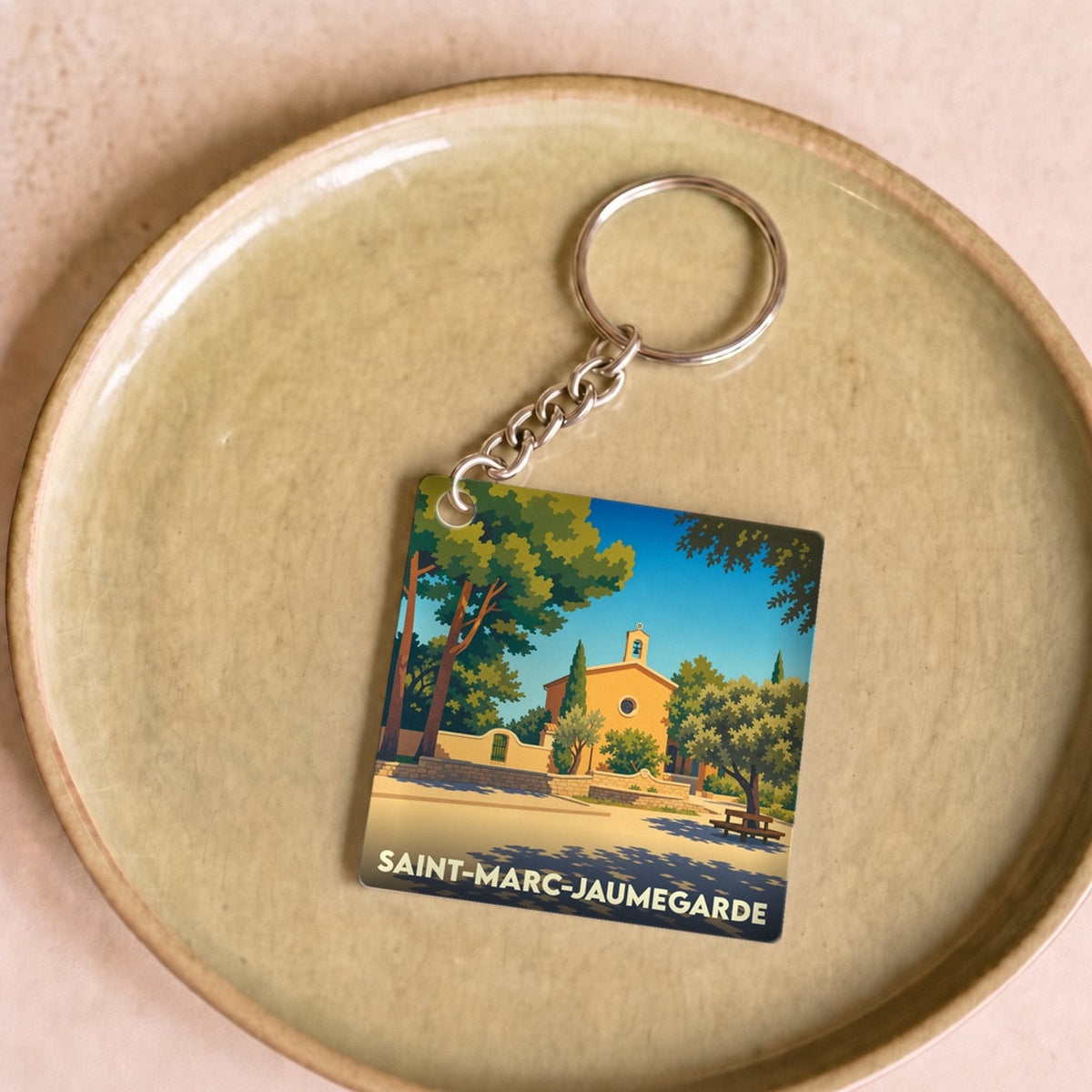 Porte-clés souvenir de la ville de Saint-Marc-Jaumegarde avec une illustration stylisée.