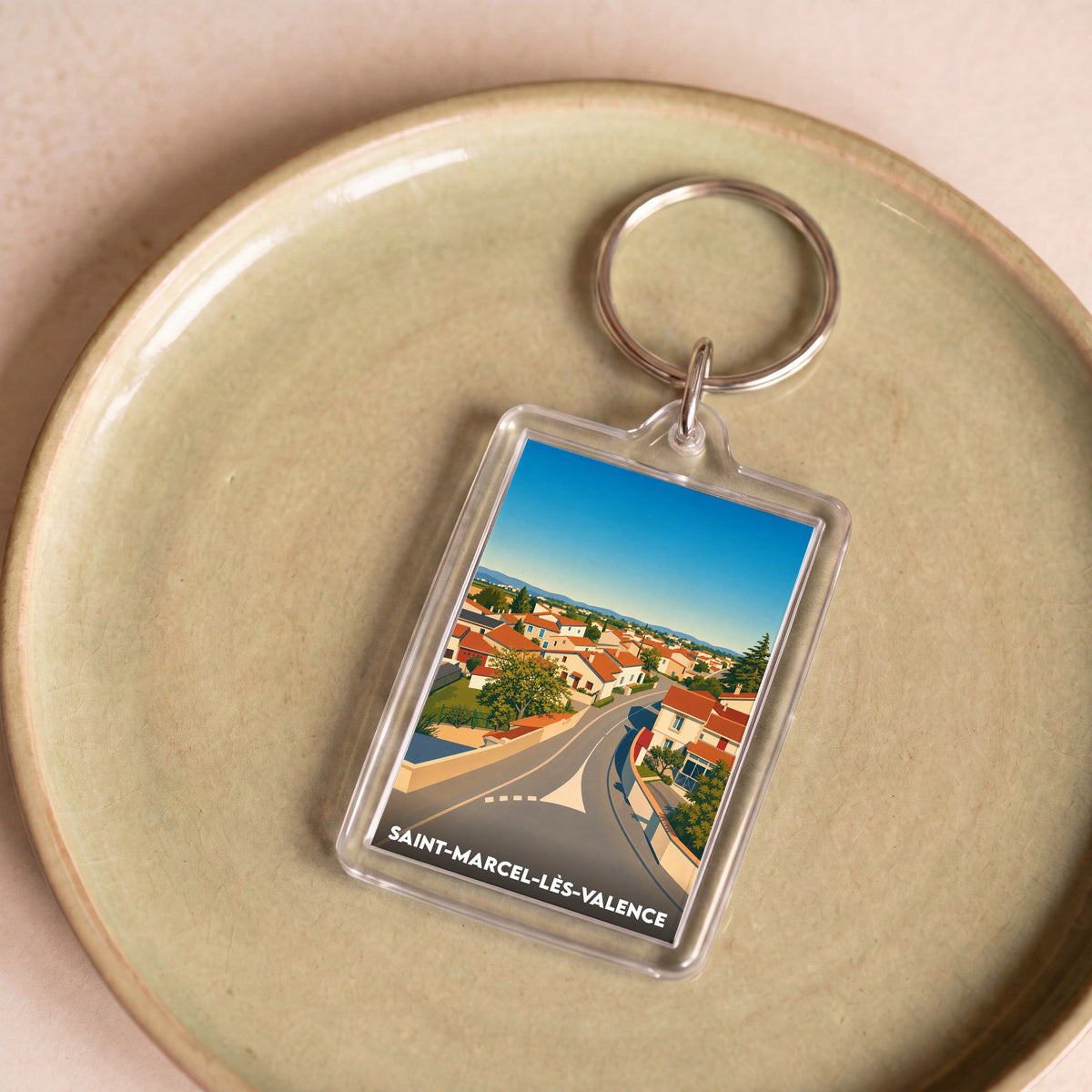 Porte-clés souvenir de la ville de Saint-Marcel-lès-Valence avec une illustration stylisée de ses maisons.