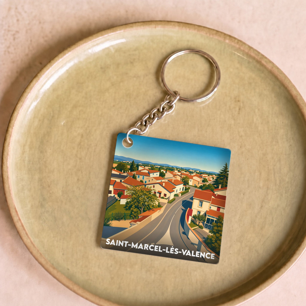Porte-clés souvenir de la ville de Saint-Marcel-lès-Valence avec une illustration stylisée de ses maisons.