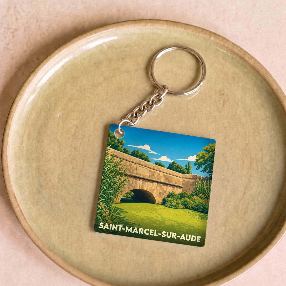 Porte-clés souvenir de la ville de Saint-Marcel-sur-Aude avec une illustration stylisée de son pont.