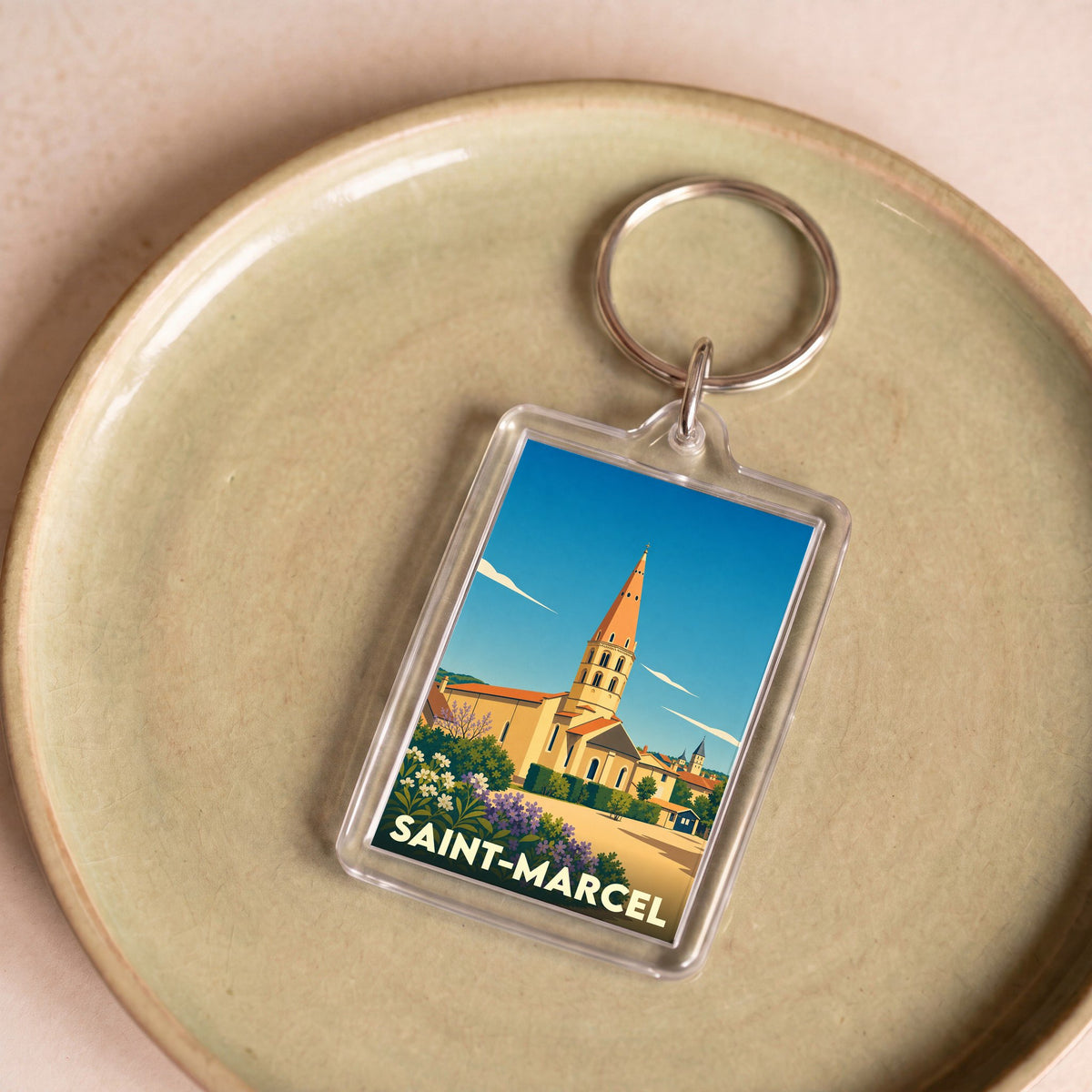 Porte-clés souvenir de la ville de Saint-Marcel avec une illustration stylisée de son église.