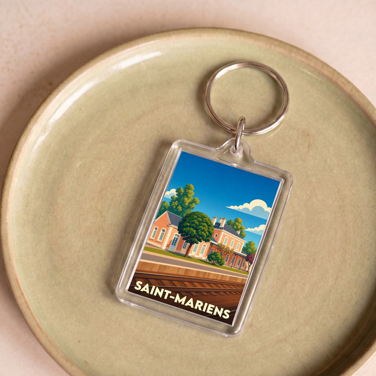 Porte-clés souvenir de la ville de Saint-Mariens avec une illustration stylisée de sa gare.