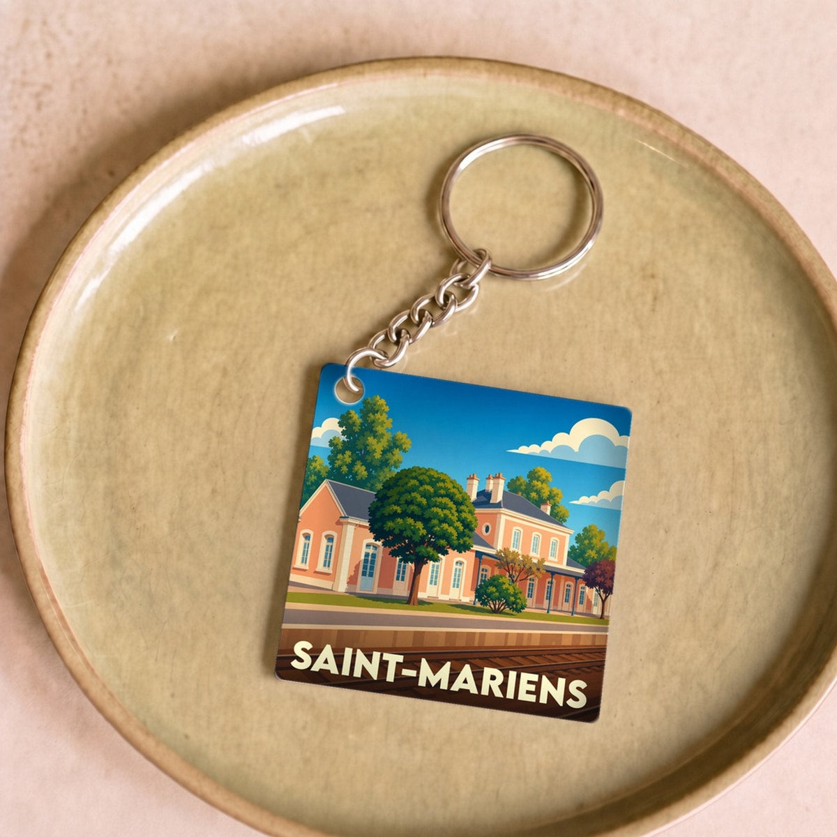Porte-clés souvenir de la ville de Saint-Mariens avec une illustration stylisée de sa gare.