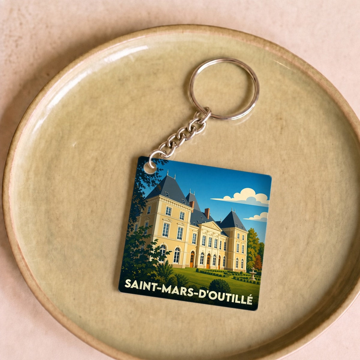 Porte-clés souvenir de la ville de Saint-Mars-d'Outillé avec une illustration stylisée de son château.