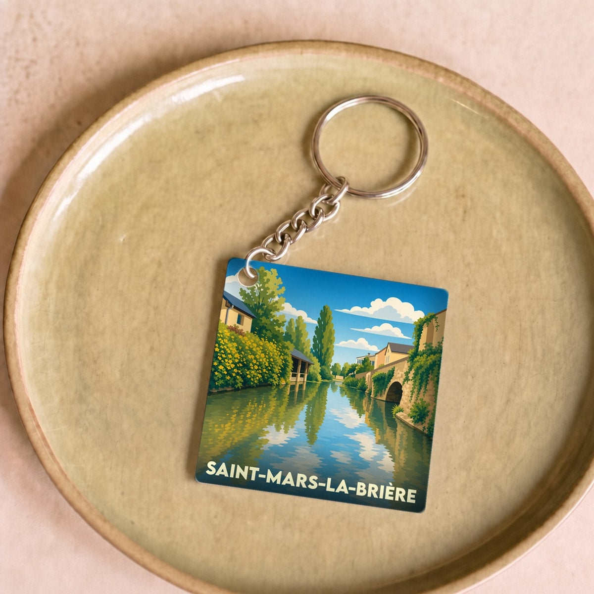 Porte-clés souvenir de la ville de Saint-Mars-la-Brière avec une illustration stylisée.