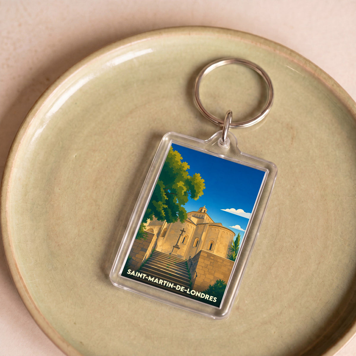 Porte-clés souvenir de Saint-Martin-de-Londres avec une illustration stylisée de son église romane.
