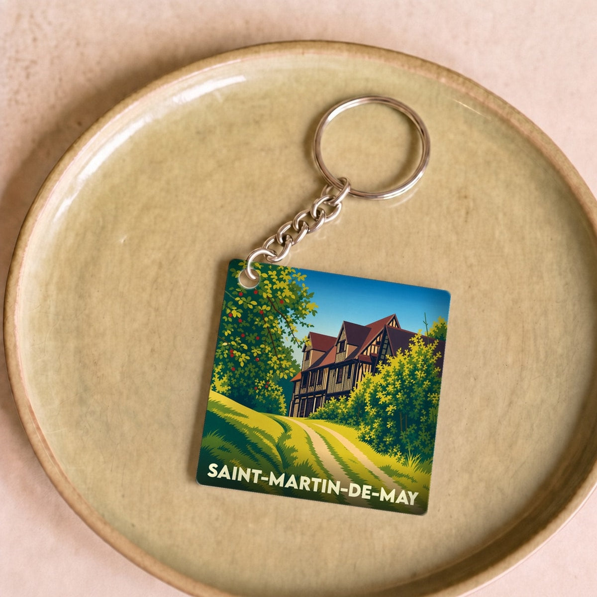 Porte-clés souvenir de la ville de Saint-Martin-de-May avec une illustration stylisée.