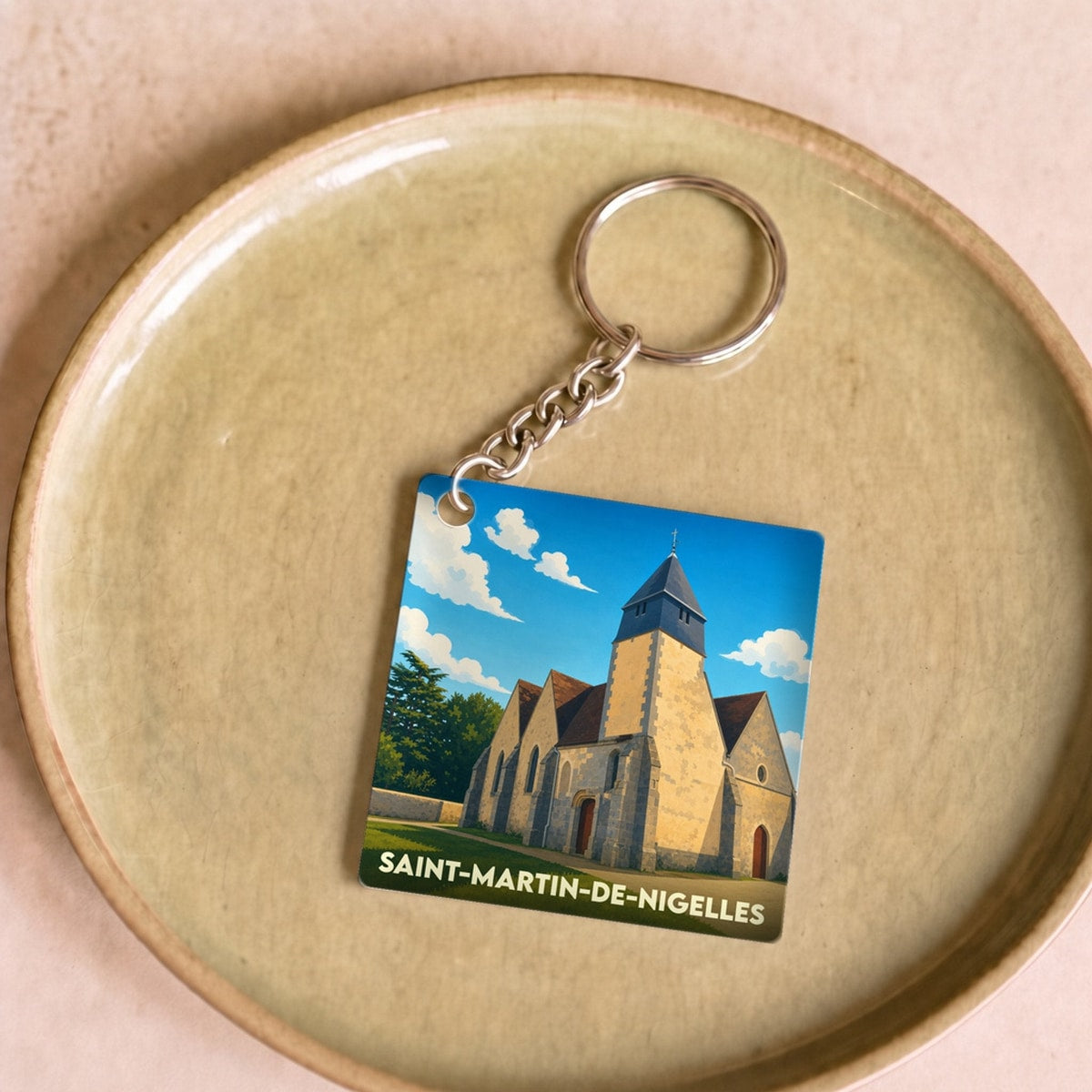 Porte-clés souvenir de la ville de Saint-Martin-de-Nigelles avec une illustration stylisée de son église.