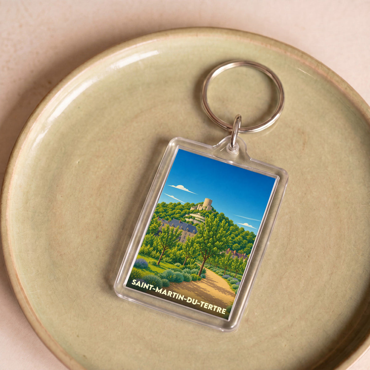 Porte-clés souvenir de la ville de Saint-Martin-du-Tertre avec une illustration stylisée de son paysage.