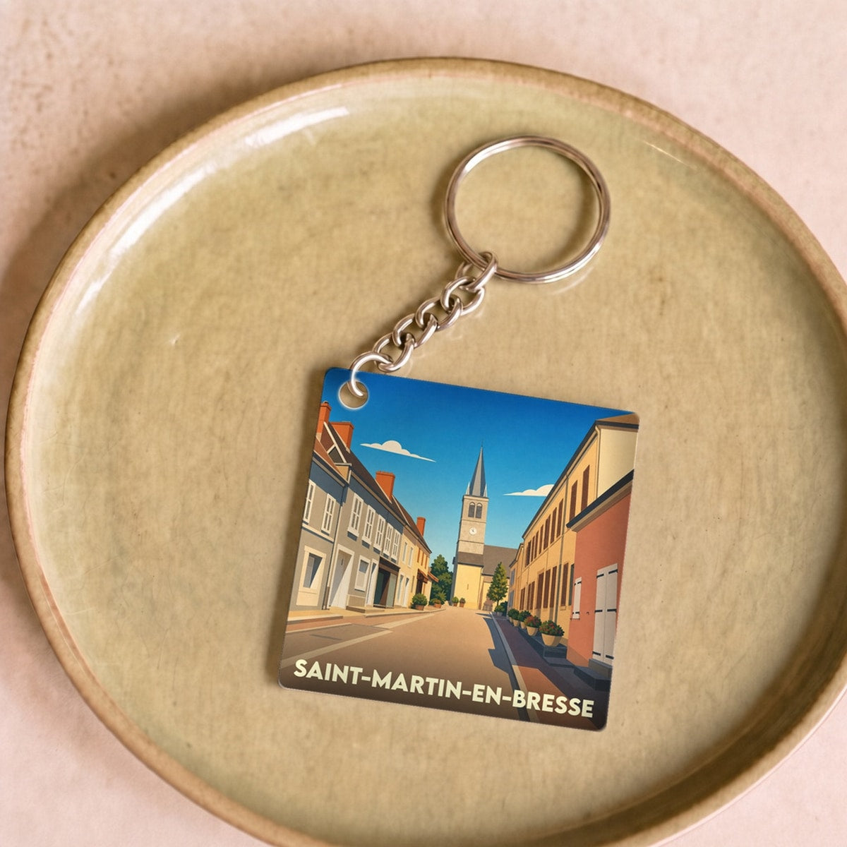 Porte-clés souvenir de la ville de Saint-Martin-en-Bresse avec une illustration stylisée.