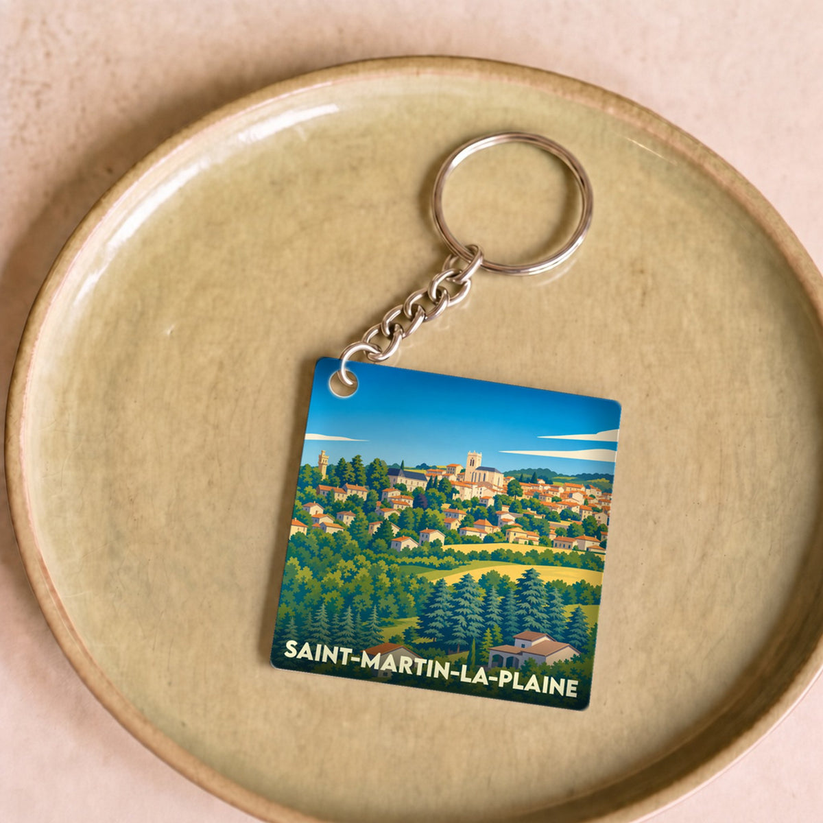 Porte-clés souvenir de la ville de Saint-Martin-la-Plaine avec une illustration stylisée.