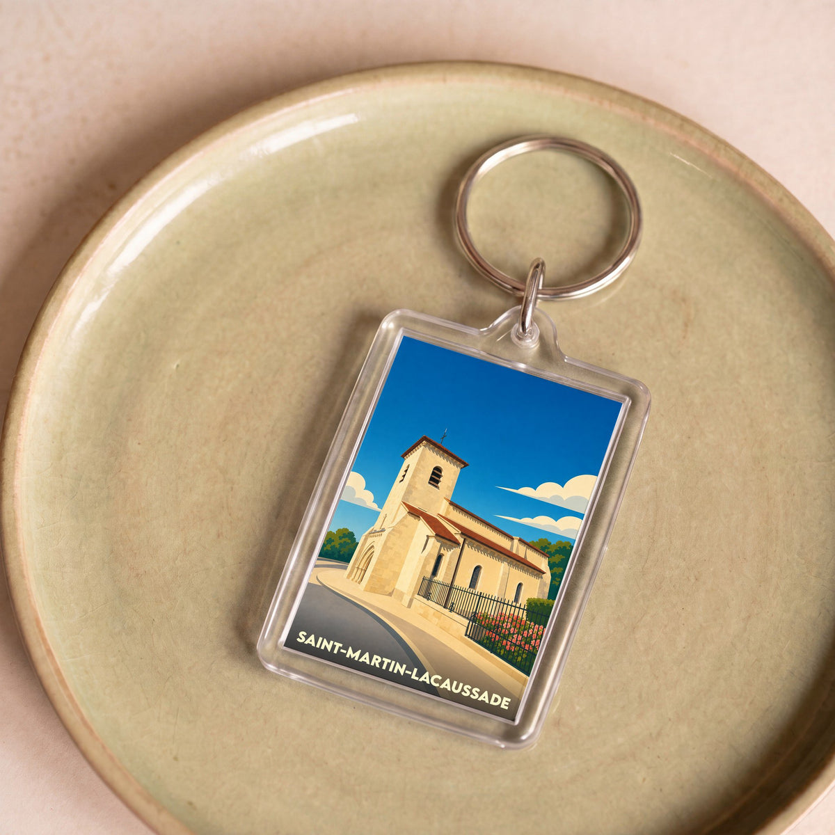 Porte-clés souvenir de la ville de Saint-Martin-Lacaussade avec une illustration stylisée de son église.