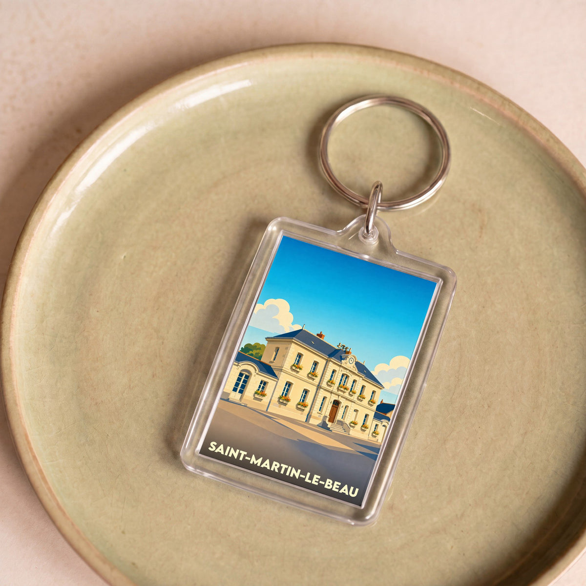 Porte-clés souvenir de la ville de Saint-Martin-le-Beau avec une illustration stylisée.