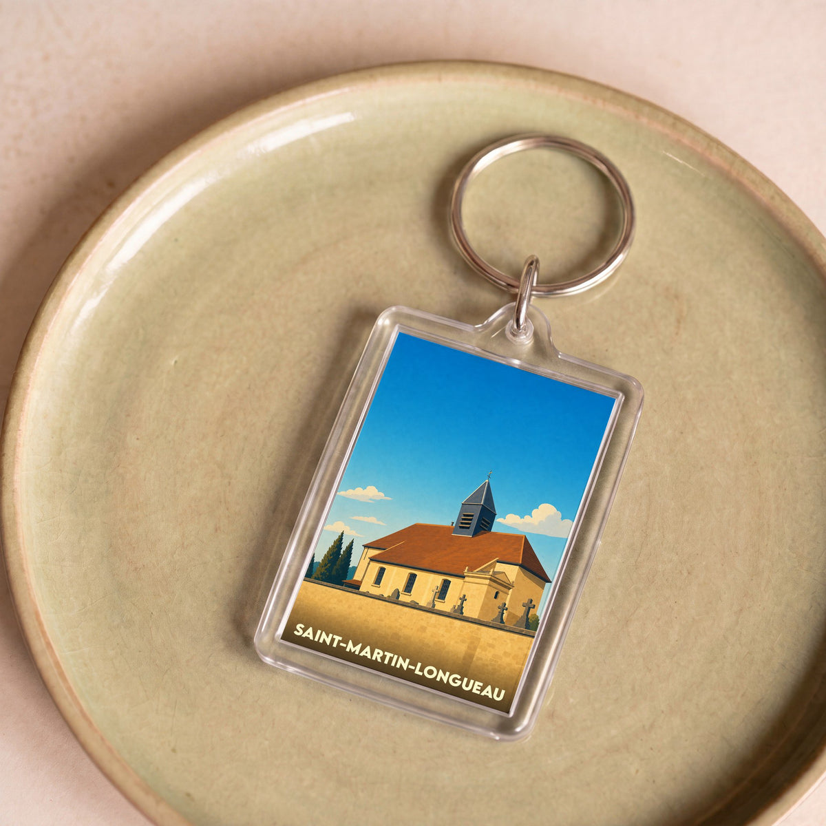 Porte-clés souvenir de la ville de Saint-Martin-Longueau avec une illustration stylisée de son église.