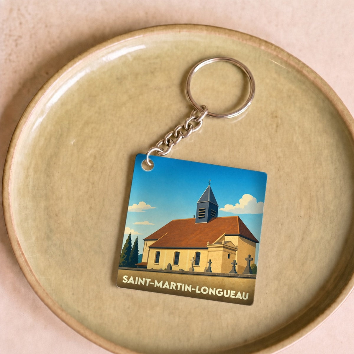 Porte-clés souvenir de la ville de Saint-Martin-Longueau avec une illustration stylisée de son église.