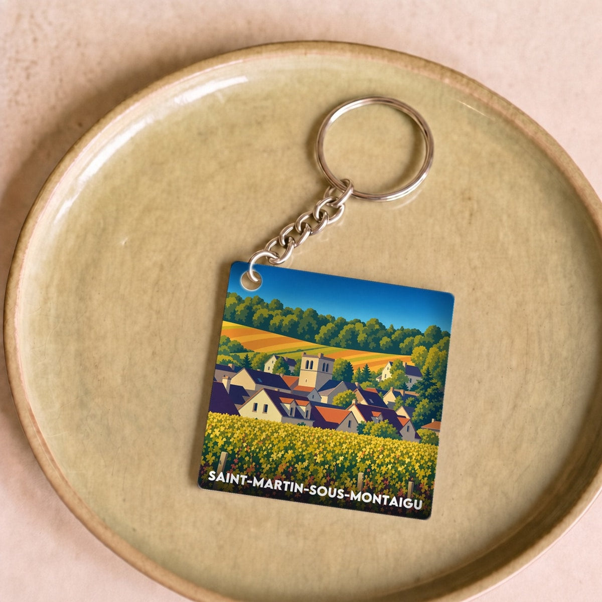 Porte-clés souvenir de Saint-Martin-sous-Montaigu avec une illustration stylisée du village.