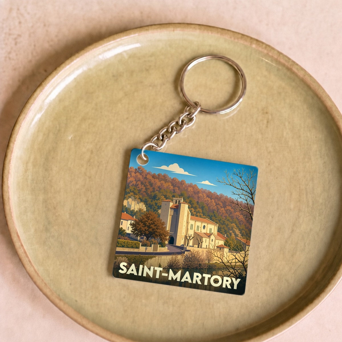 Porte-clés souvenir de la ville de Saint-Martory avec une illustration stylisée.