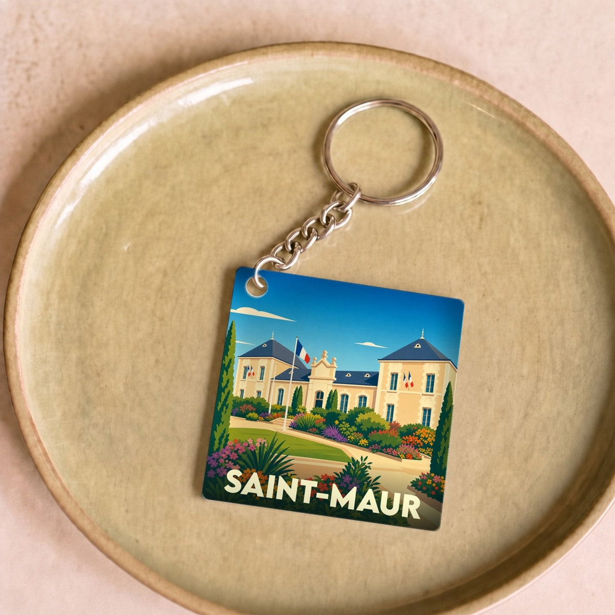 Porte-clés souvenir de la ville de Saint-Maur avec une illustration stylisée de son hôtel de ville fleuri.