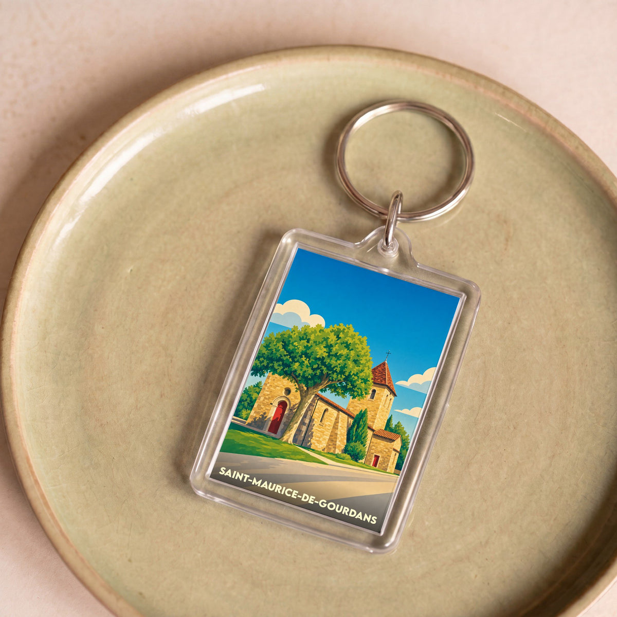 Porte-clés souvenir de la ville de Saint-Maurice-de-Gourdans avec une illustration stylisée de son église.