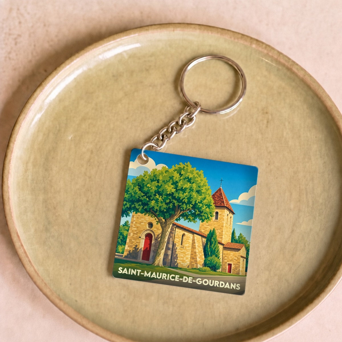 Porte-clés souvenir de la ville de Saint-Maurice-de-Gourdans avec une illustration stylisée de son église.
