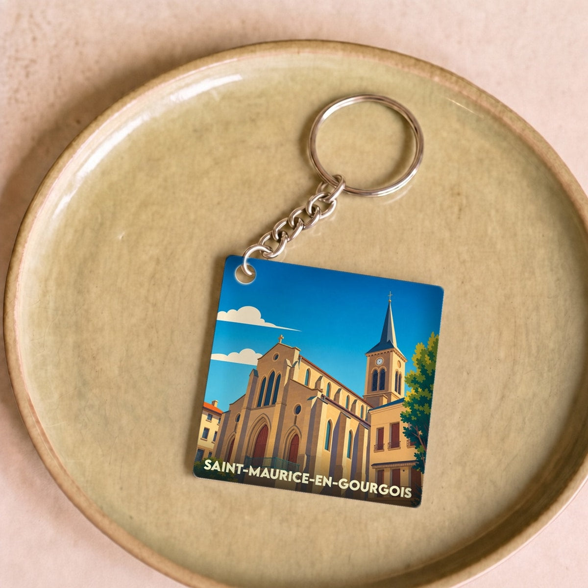 Porte-clés souvenir de la ville de Saint-Maurice-en-Gourgois avec une illustration stylisée de son église.