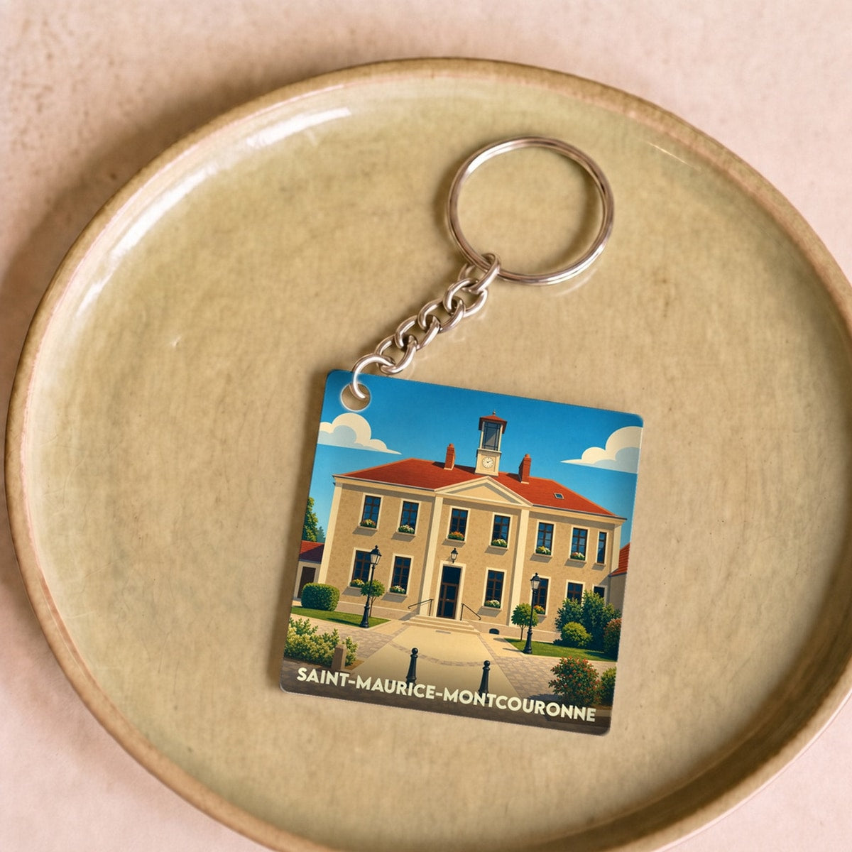 Porte-clés souvenir de la ville de Saint-Maurice-Montcouronne avec une illustration stylisée de sa mairie.