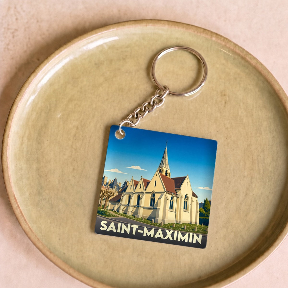 Porte-clés souvenir de la ville de Saint-Maximin avec une illustration stylisée de son église.