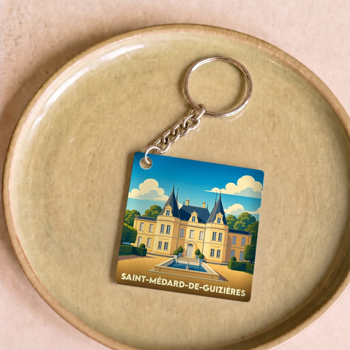 Porte-clés souvenir de la ville de Saint-Médard-de-Guizières avec une illustration stylisée d'un château.