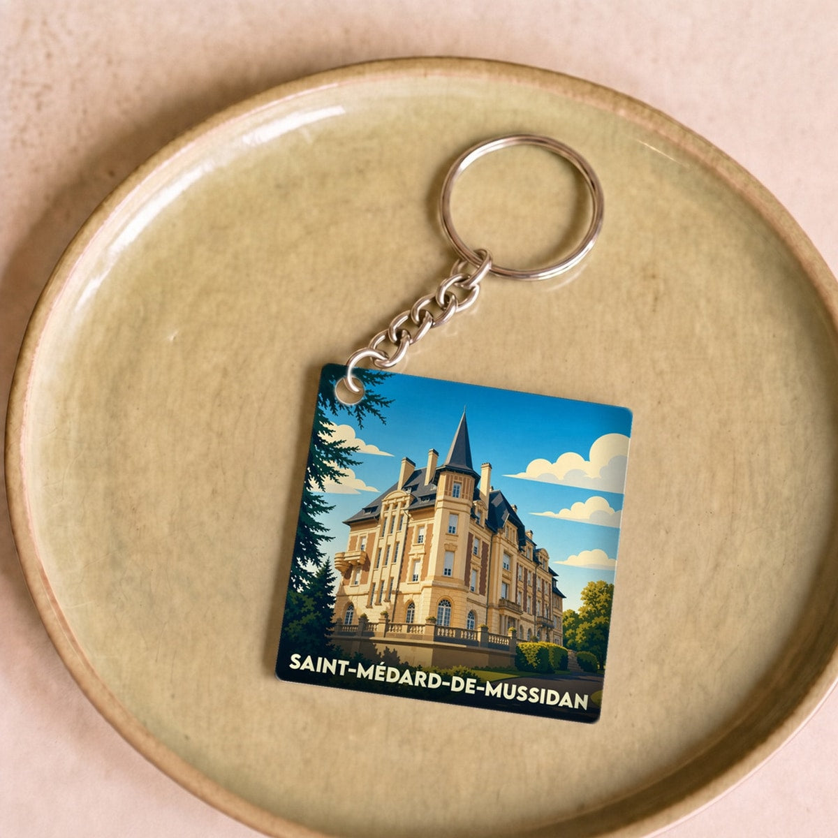 Porte-clés souvenir de la ville de Saint-Médard-de-Mussidan avec une illustration stylisée de son château.