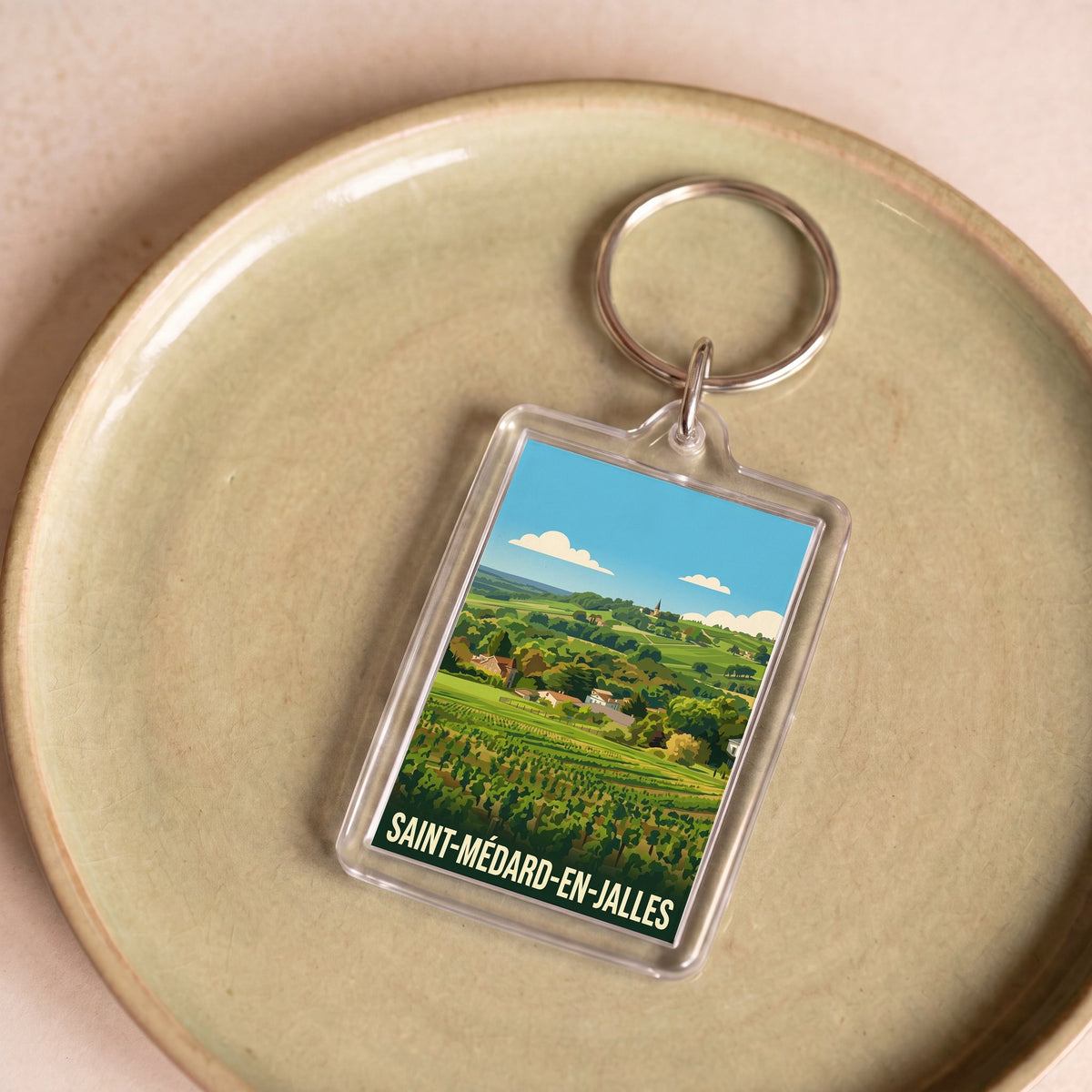 Porte-clés souvenir de la ville de Saint-Médard-en-Jalles avec une illustration stylisée de paysages.