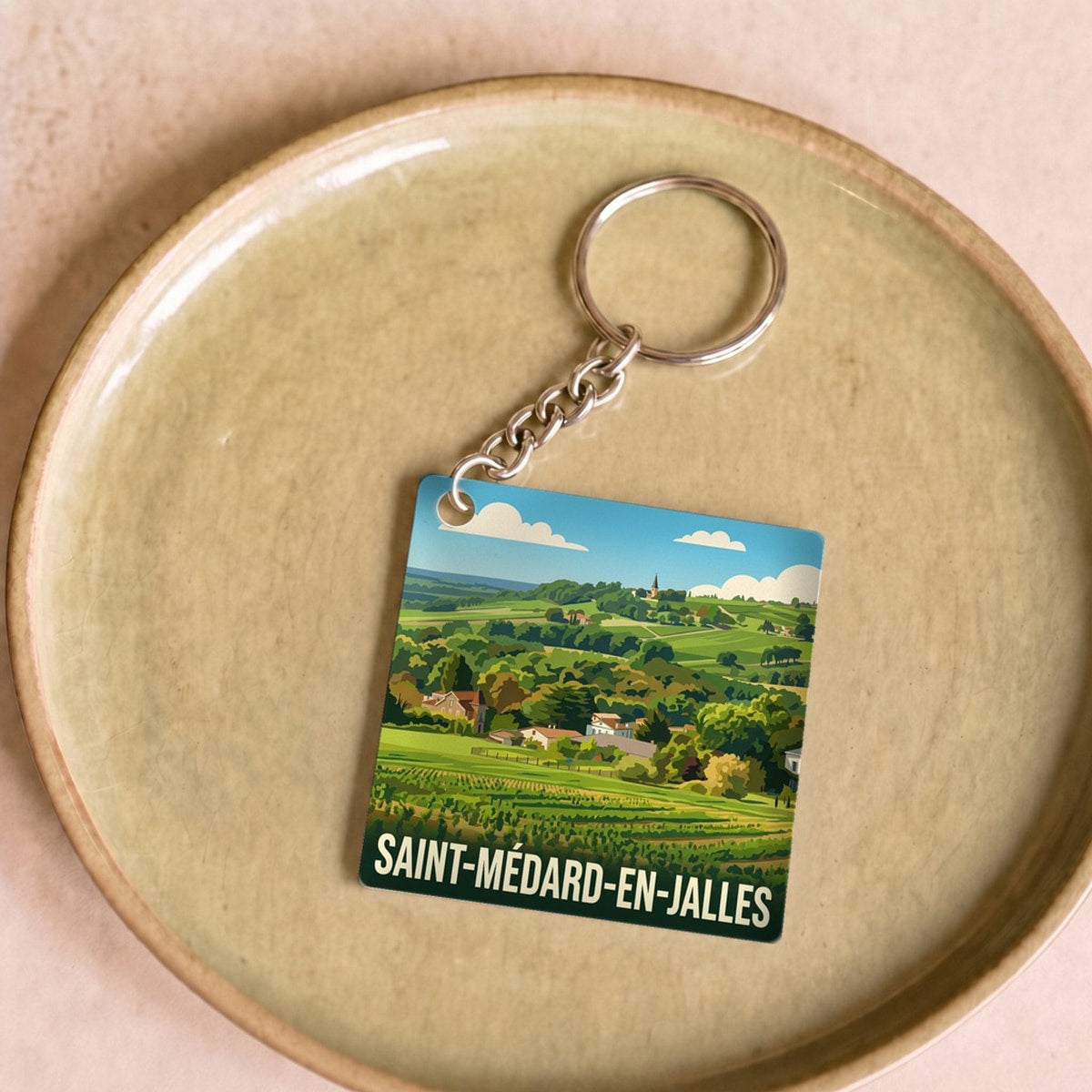 Porte-clés souvenir de la ville de Saint-Médard-en-Jalles avec une illustration stylisée de paysages.