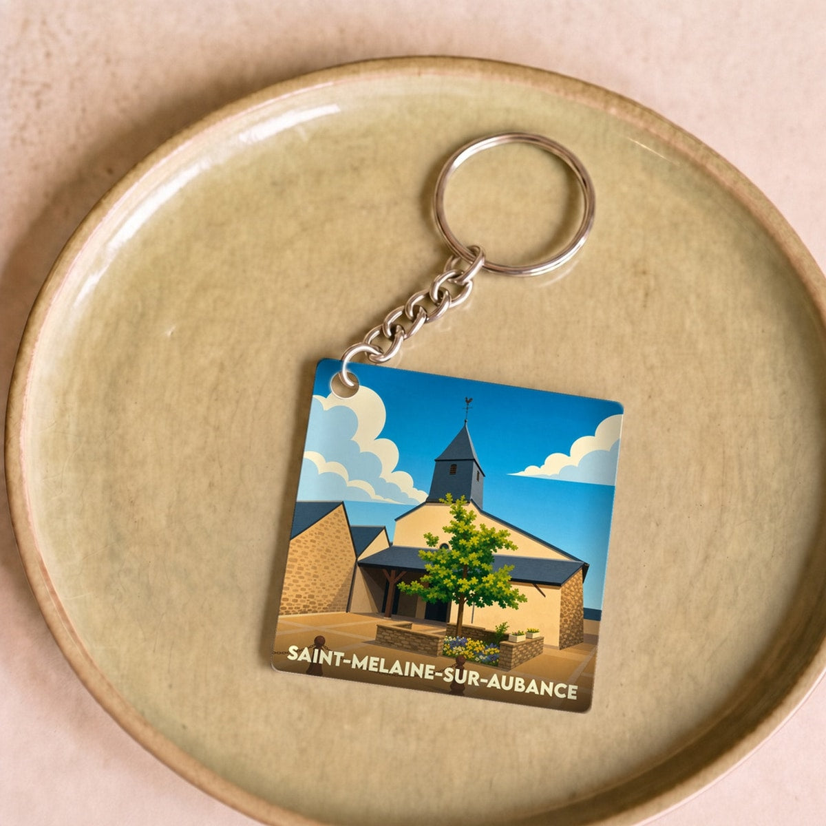 Porte-clés souvenir de la ville de Saint-Melaine-sur-Aubance avec une illustration stylisée.