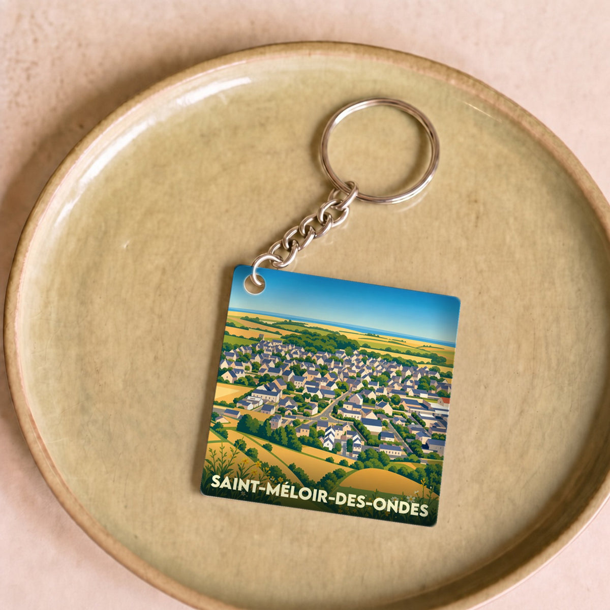 Porte-clés souvenir de la ville de Saint-Méloir-des-Ondes avec une illustration stylisée.