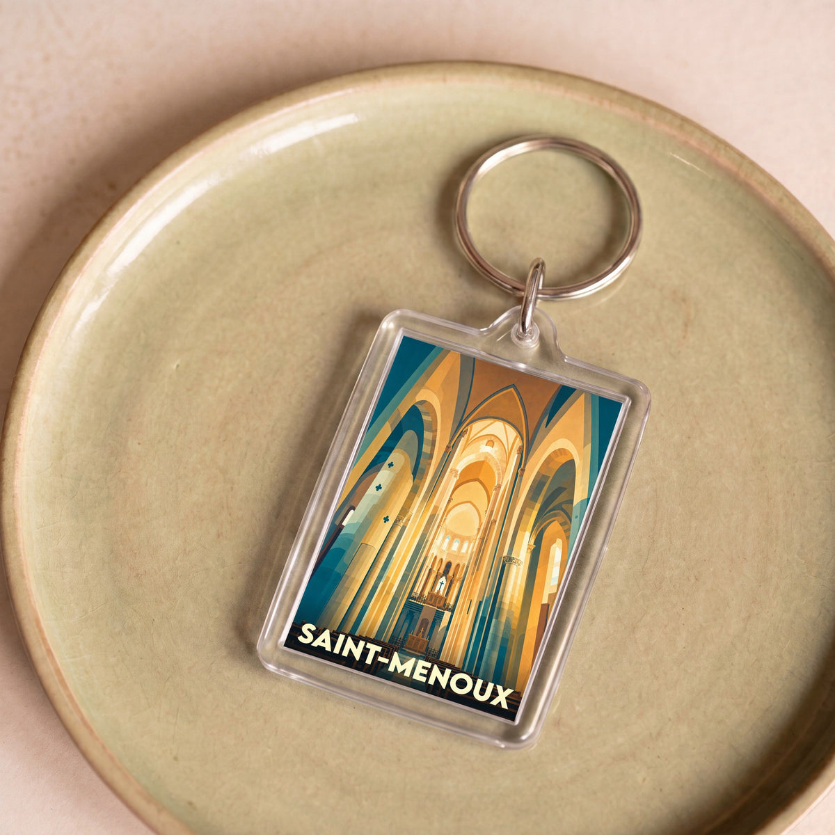 Porte-clés souvenir de la ville de Saint-Menoux avec une illustration stylisée de l'intérieur de son église.