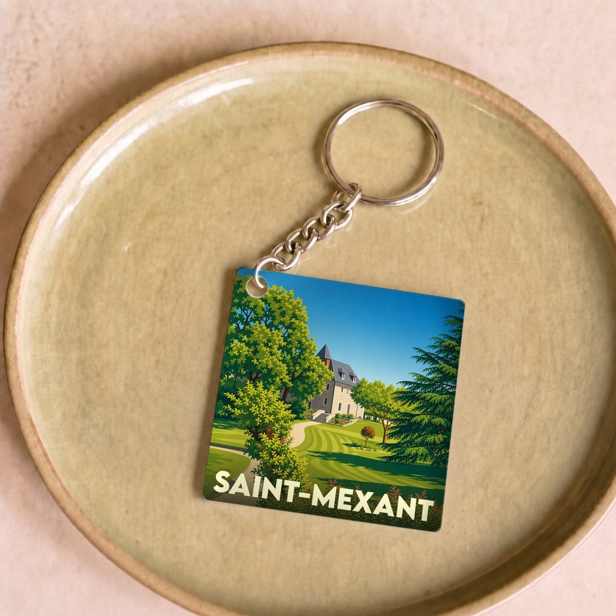 Porte-clés souvenir de la ville de Saint-Mexant avec une illustration stylisée.
