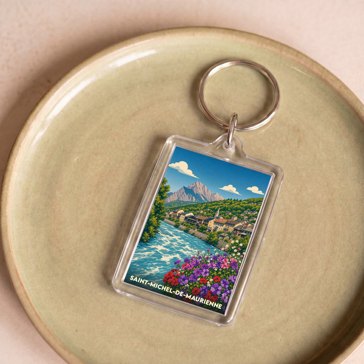 Porte-clés souvenir de la ville de Saint-Michel-de-Maurienne avec une illustration stylisée.
