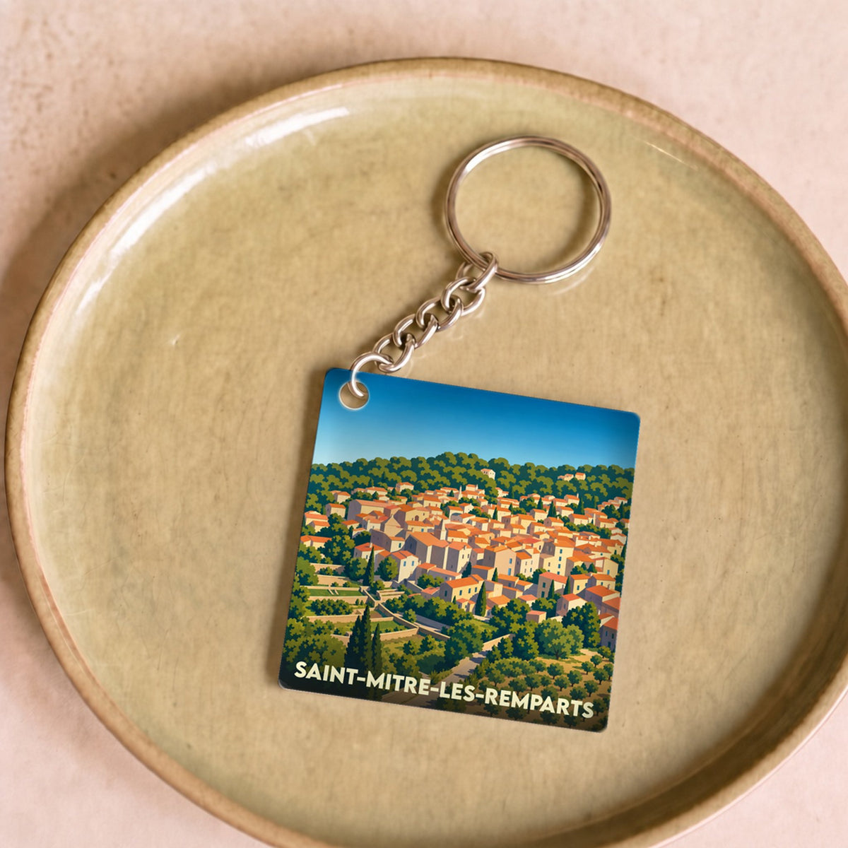 Porte-clés souvenir de la ville de Saint-Mitre-les-Remparts avec une illustration stylisée.