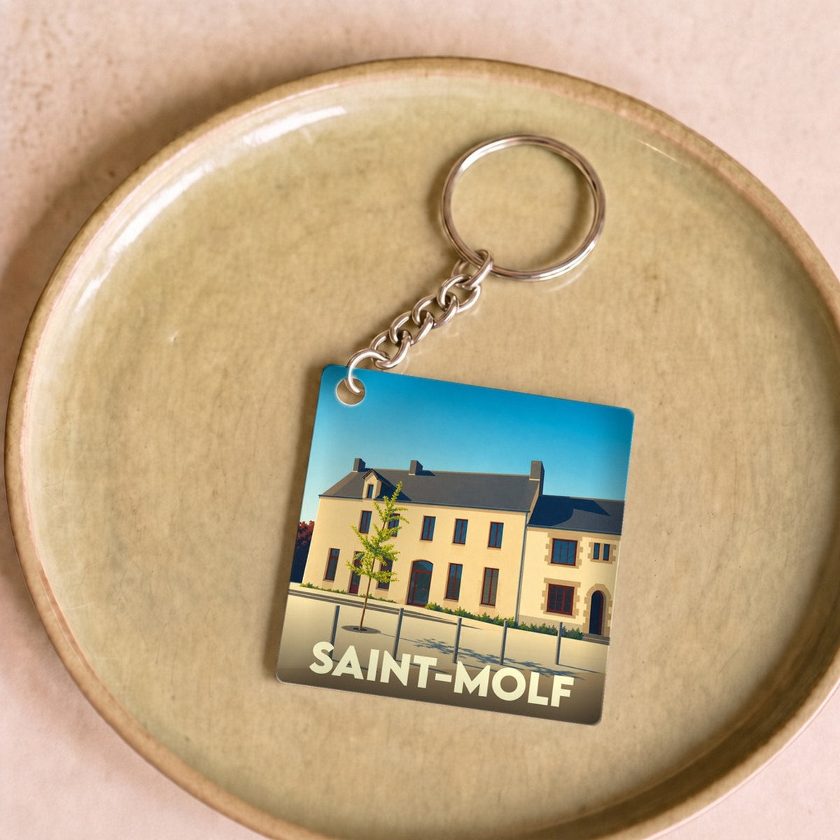 Porte-clés souvenir de la ville de Saint-Molf avec une illustration stylisée.