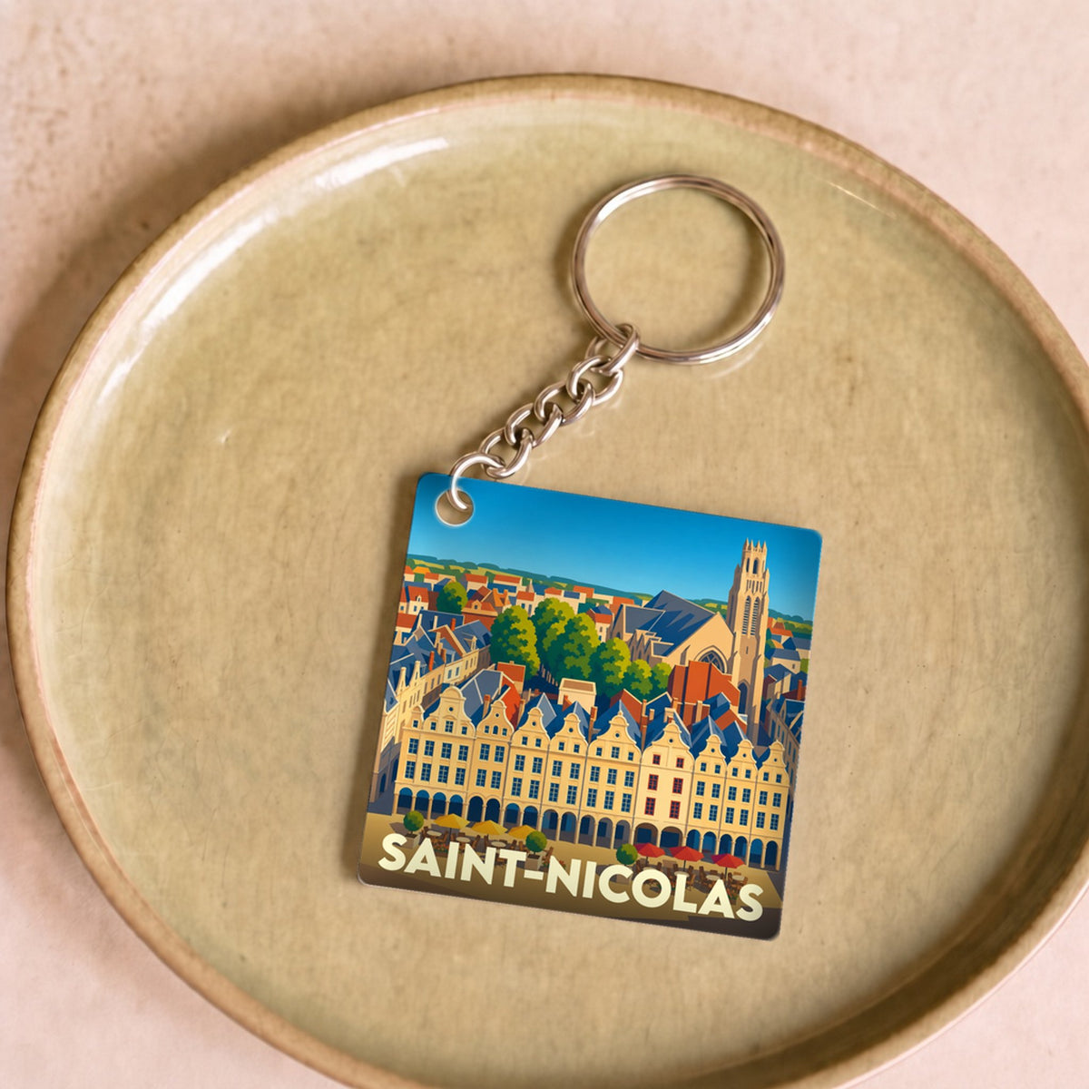 Porte-clés souvenir de la ville de Saint-Nicolas avec une illustration stylisée de sa place et de son église.