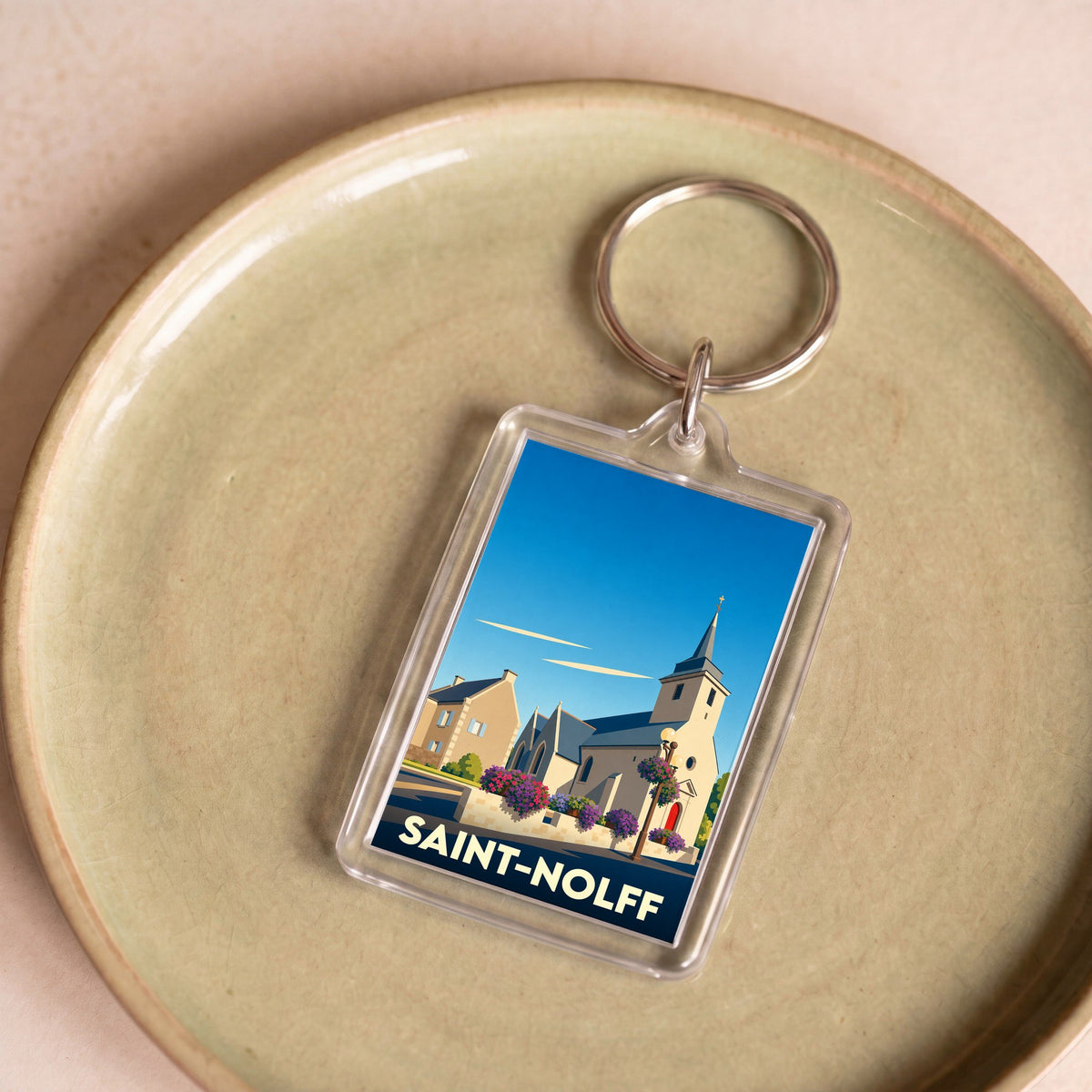 Porte-clés souvenir de la ville de Saint-Nolff avec une illustration stylisée de son église.