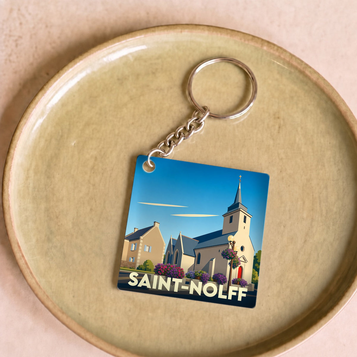 Porte-clés souvenir de la ville de Saint-Nolff avec une illustration stylisée de son église.
