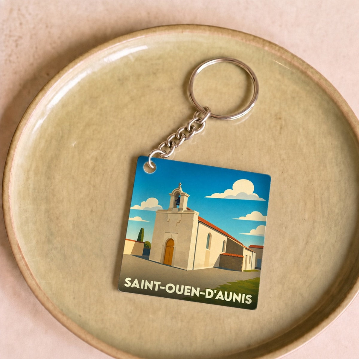 Porte-clés souvenir de la ville de Saint-Ouen-d'Aunis avec une illustration stylisée de son église.
