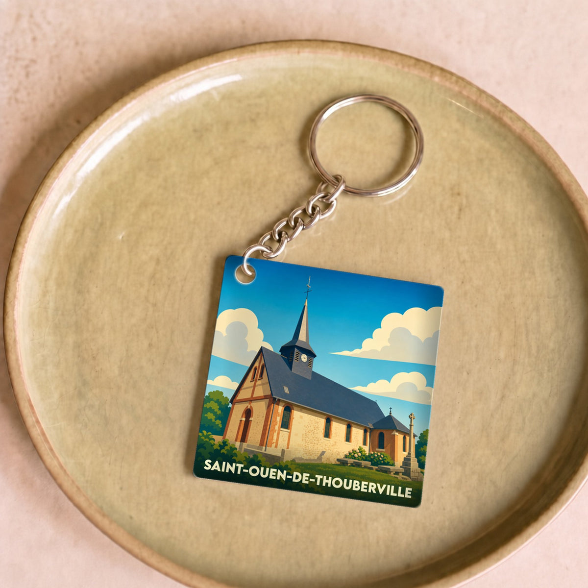 Porte-clés souvenir de la ville de Saint-Ouen-de-Thouberville avec une illustration stylisée de son église.