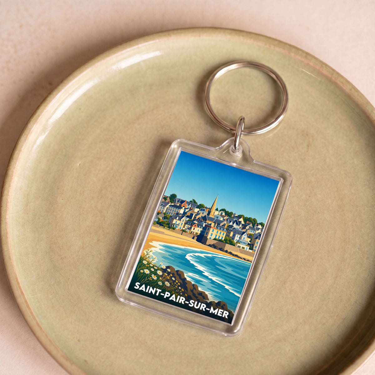 Porte-clés souvenir de la ville de Saint-Pair-sur-Mer avec une illustration stylisée du bord de mer.