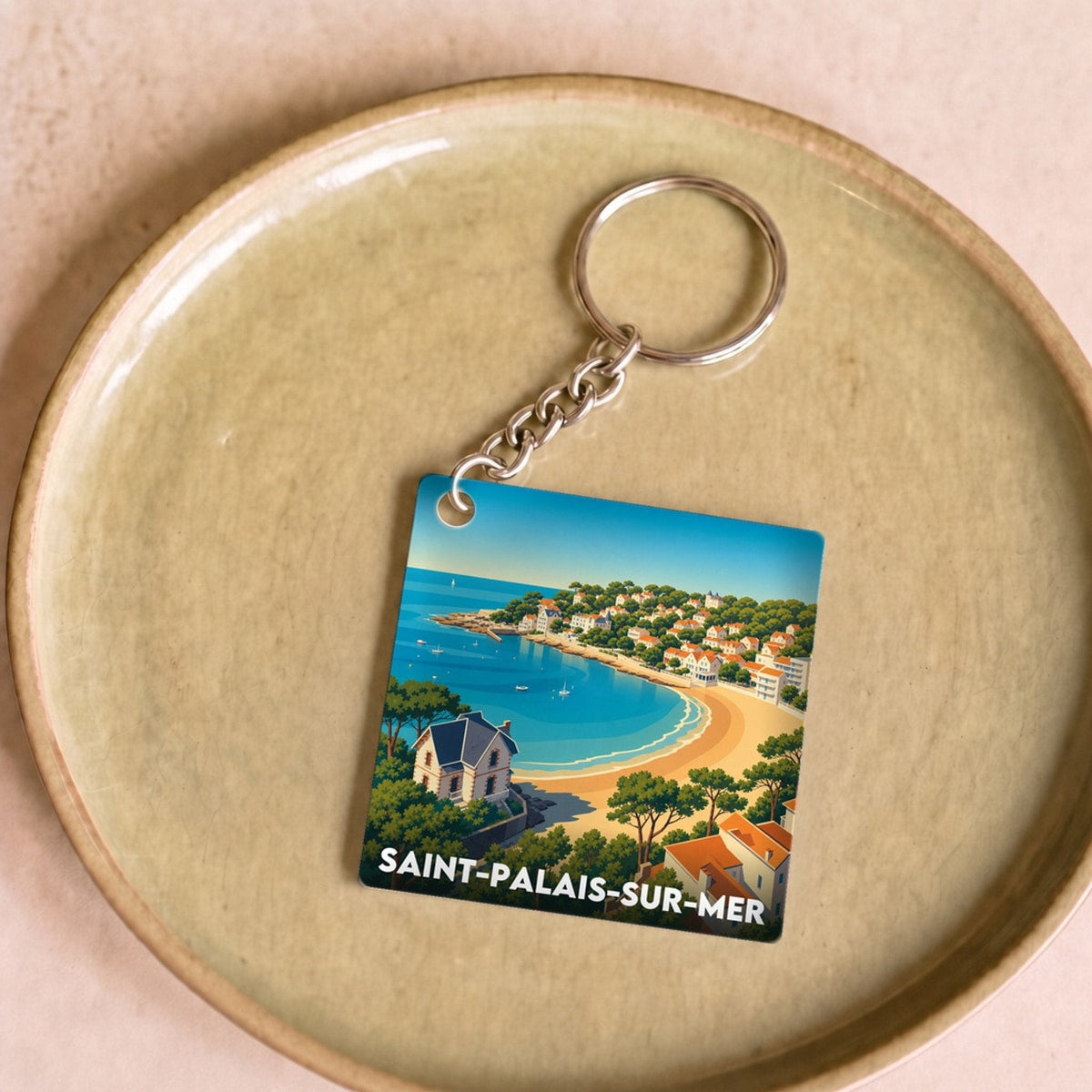 Porte-clés souvenir de la ville de Saint-Palais-sur-Mer avec une illustration stylisée de son littoral.