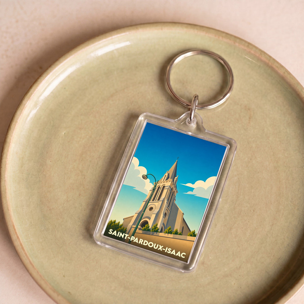 Porte-clés souvenir de la ville de Saint-Pardoux-Isaac avec une illustration stylisée de son église.